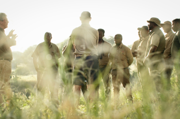 Tanzaniaanse safarigidsen in het veld tijdens een opleiding, met focus op routeplanning en natuurkennis